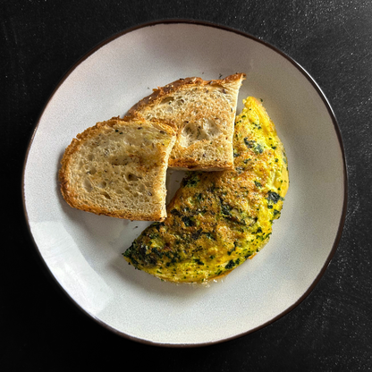 Tortilla proteica con espinacas y champiñones, sobre pan de masa madre