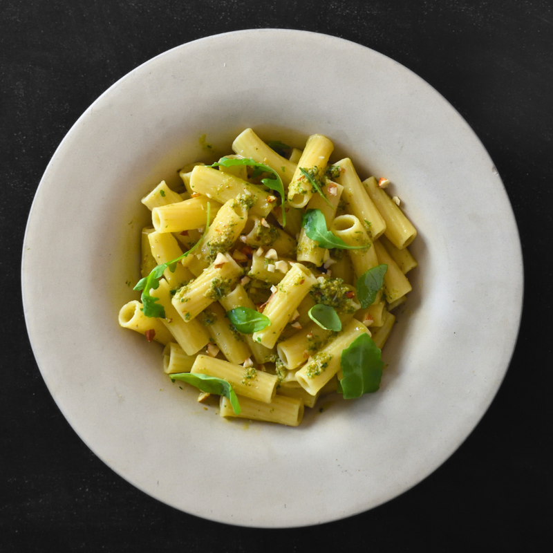Rigatoni fresco con pesto de rúcula y avellanas
