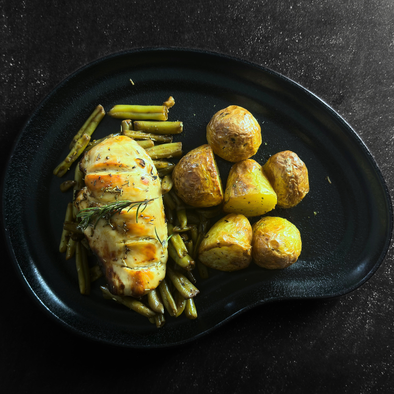 Pechuga de pollo sobre espárragos y patatas baby