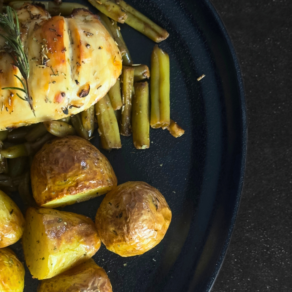 Pechuga de pollo sobre espárragos y patatas baby