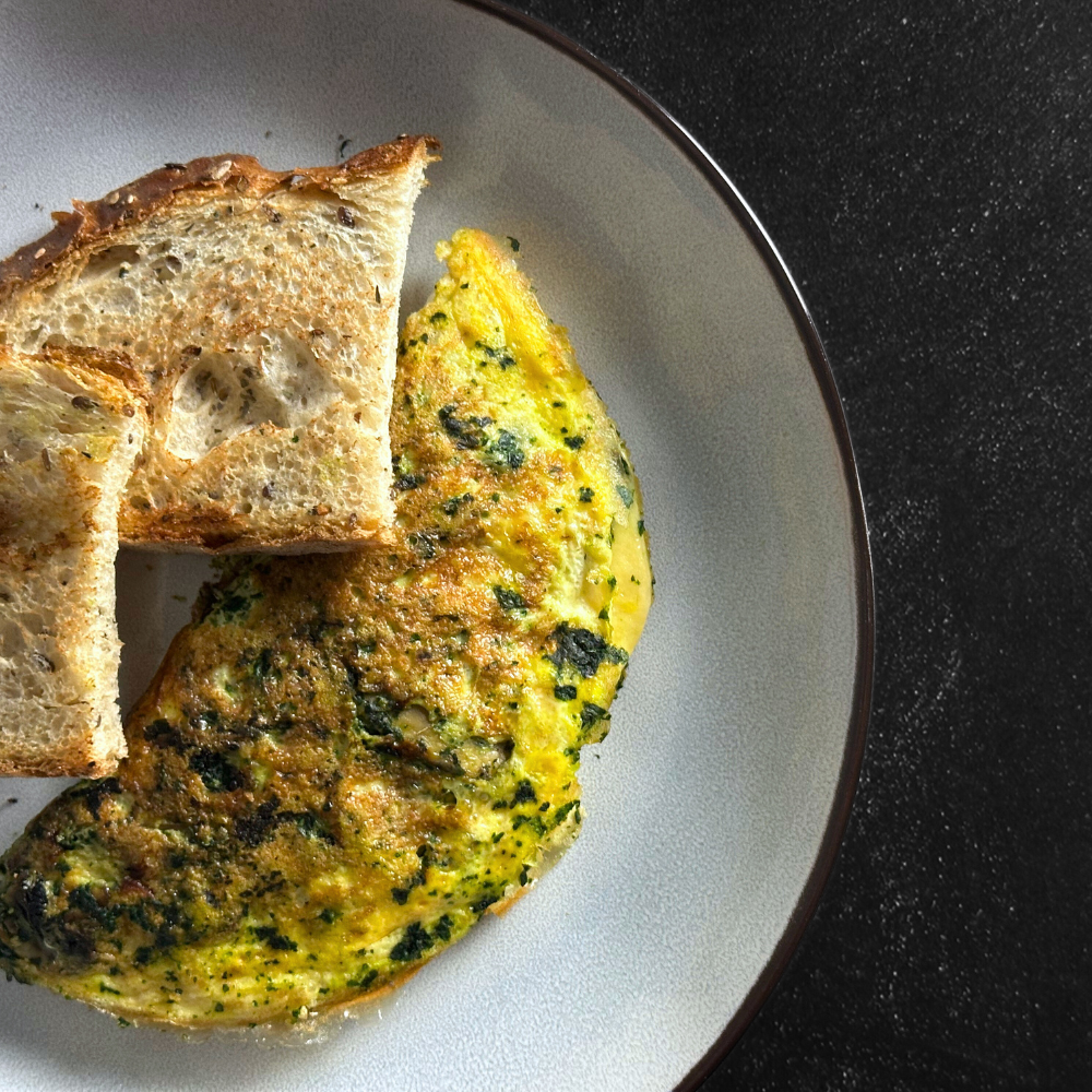 Tortilla proteica con espinacas y champiñones, sobre pan de masa madre
